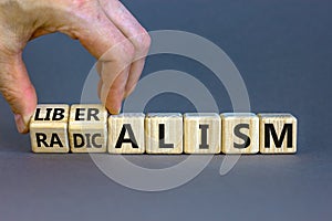 Radicalism or liberalism symbol. Male hand turns cubes and changes the word `radicalism` to `liberalism`. Beautiful grey