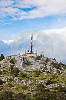 A radio communications tower on a stone hill