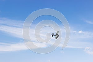 Radio controlled toy airplane against blue sky with white clouds