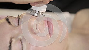 Radio frequency treatment. Beautician does rf-lifting procedure for a woman in a beauty saloon.