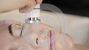 Radio frequency treatment. Beautician does rf-lifting procedure for a woman in a beauty saloon.