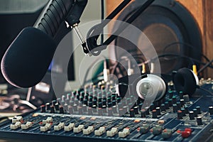 Radio host microphone, mixing console and headphones close-up