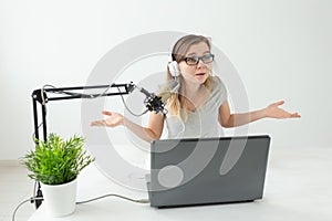 Radio host, streamer and blogger concept - Woman working as radio host at radio station sitting in front of microphone