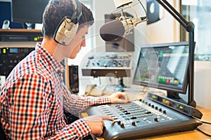 Radio host using sound mixer in studio