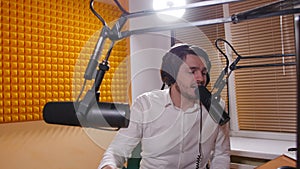 Radio and live broadcast concept. Young man with headphones talking on mic, online radio.