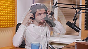 Radio and live broadcast concept. Young man with headphones talking on mic, online radio.