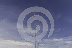 Radio mast against blue sky with cloud, copyspace