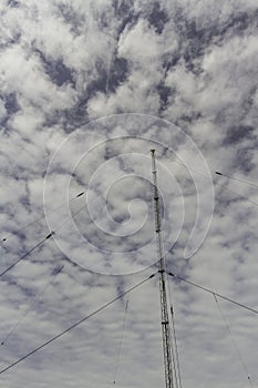Radio mast against blue sky with cloud, wide angle