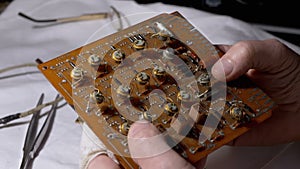 Radio Technician Examines Precious Radio Transistors, on an Electronic Board.