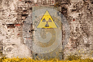 Radioactive ionizing radiation danger symbol painted on the old massive rusted iron door