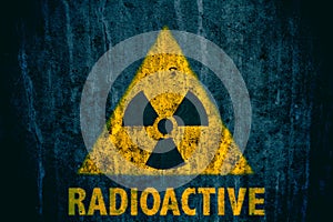 Radioactive ionizing radiation danger symbol with word radioactive below painted on a massive concrete wall