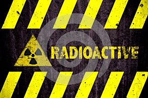 Radioactive ionizing radiation or nuclear energy danger symbol word yellow hazard black stripes painted on concrete