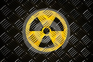 Radioactive ionizing radiation round yellow and black danger symbol painted on a massive steel checker metal diamond plate