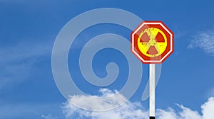 The radioactive symbol on red warning sign with blue sky background