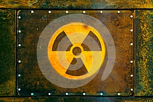 Radioactive symbol: yellow nuclear radioactive ionizing radiation danger warning symbol painted on a massive rusty metal plate