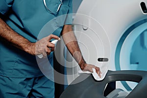 Radiographer Cleaning CT Scanner Bed