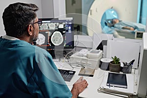 Radiographer Controlling CT Scanner At Work In Hospital photo