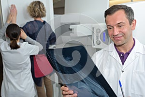Radiographer looking at xray patient in background