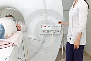 Radiologic technician and man patient lying on a CT Scan bed. preparing for MRI magnetic resonance imaging in a hospital
