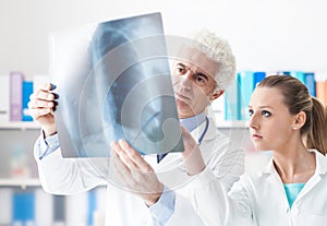 Radiologist checking an x-ray with his assistant