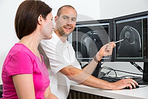 Radiologist councelling a patient using images from tomograpy or MRI