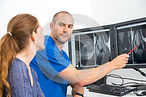 Radiologist councelling a patient using images from tomograpy or MRI photo