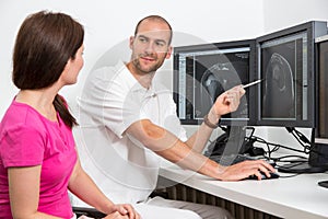 Radiologist councelling a patient using images from tomograpy or MRI photo