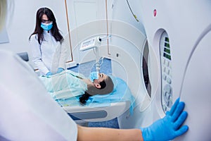 Radiologist with a female patient in the room of computed tomography