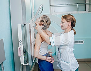 Radiologist and patient in a x-ray room. Classic ceiling-mounted x-ray system.