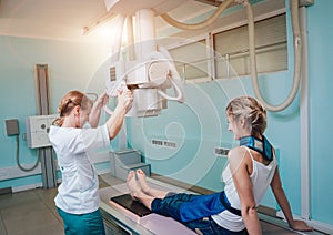 Radiologist and patient in a x-ray room. Classic ceiling-mounted x-ray system.