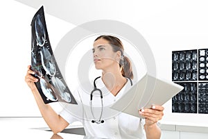 Radiologist woman checking xray, with tablet, healthcare