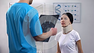 Radiologist with x-ray informing patient about results, lady listening with hope photo