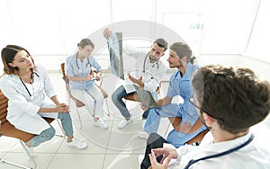 Radiologists and a surgeon discussing a radiograph of a patient