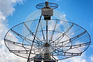 Radiotelescope on cloudy blue sky background