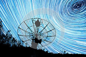 Radiotelescopes silhouettes under long star trails