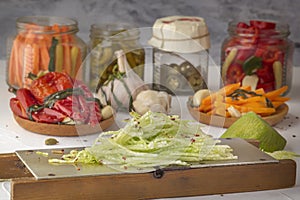 Radish grated on a hand grater on the background of differentiated products - pepper, garlic, carrots on a l table