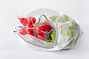 Radish vegetable in reusable mesh nylon bag, plastic free zero waste concept