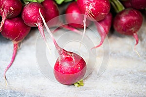 Radishes lie on each other on wooden ground