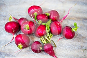 Radishes lie on each other on wooden ground