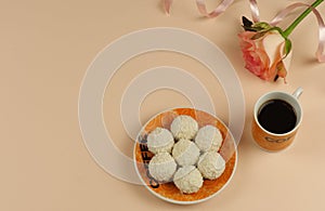 Raffaello sweets on a saucer, a cup of black coffee, a pink rose. photo