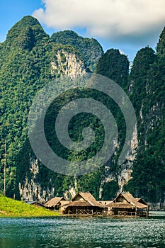 Raft house on the river with mountain on background.