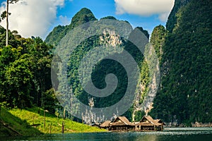 Raft house on the river with mountain on background.