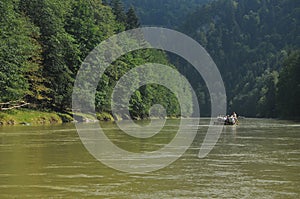 Rafting on the Dunajec River in the Pieniny National Park on wooden folding shuttles tied with a rope. Rafters paddling on a rapid
