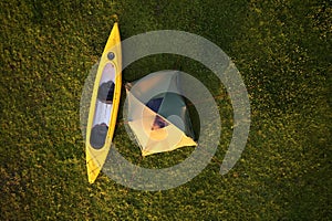 Rafting on kayaks. A tent camp stands on the river bank.