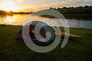 Rafting on kayaks. A tent camp stands on the river bank.