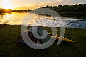 Rafting on kayaks. A tent camp stands on the river bank.