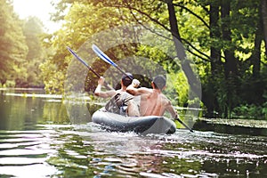 Rafting on the river in a kayak in the summer season. Leisure. Two people in the boat row with oars