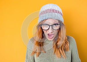 Rage young woman screaming, isolated on yellow background. Frustrated girl