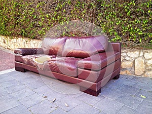 Ragged leather sofa dumped on a street