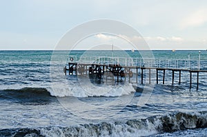 The raging sea and wooden jetty. Storm.